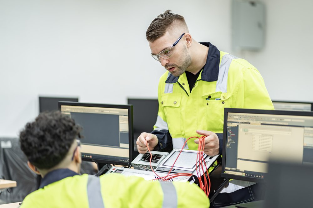 Technician diagnosing fault on an industrial PLC cabinet